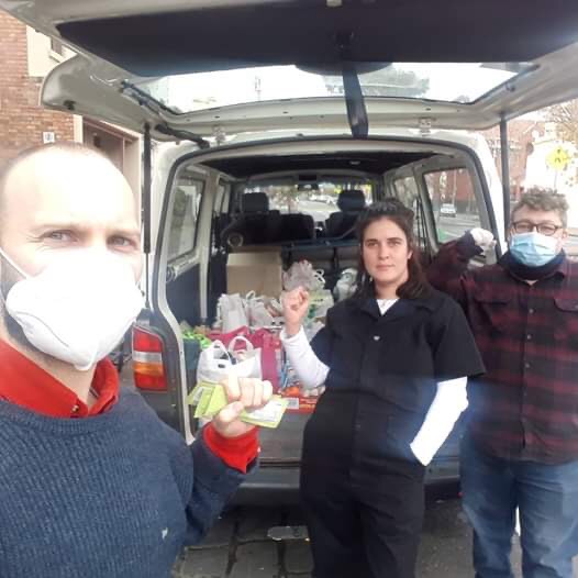 3 RAHU members organising mutual aid, first raised in front of a van showing  some donated goods.