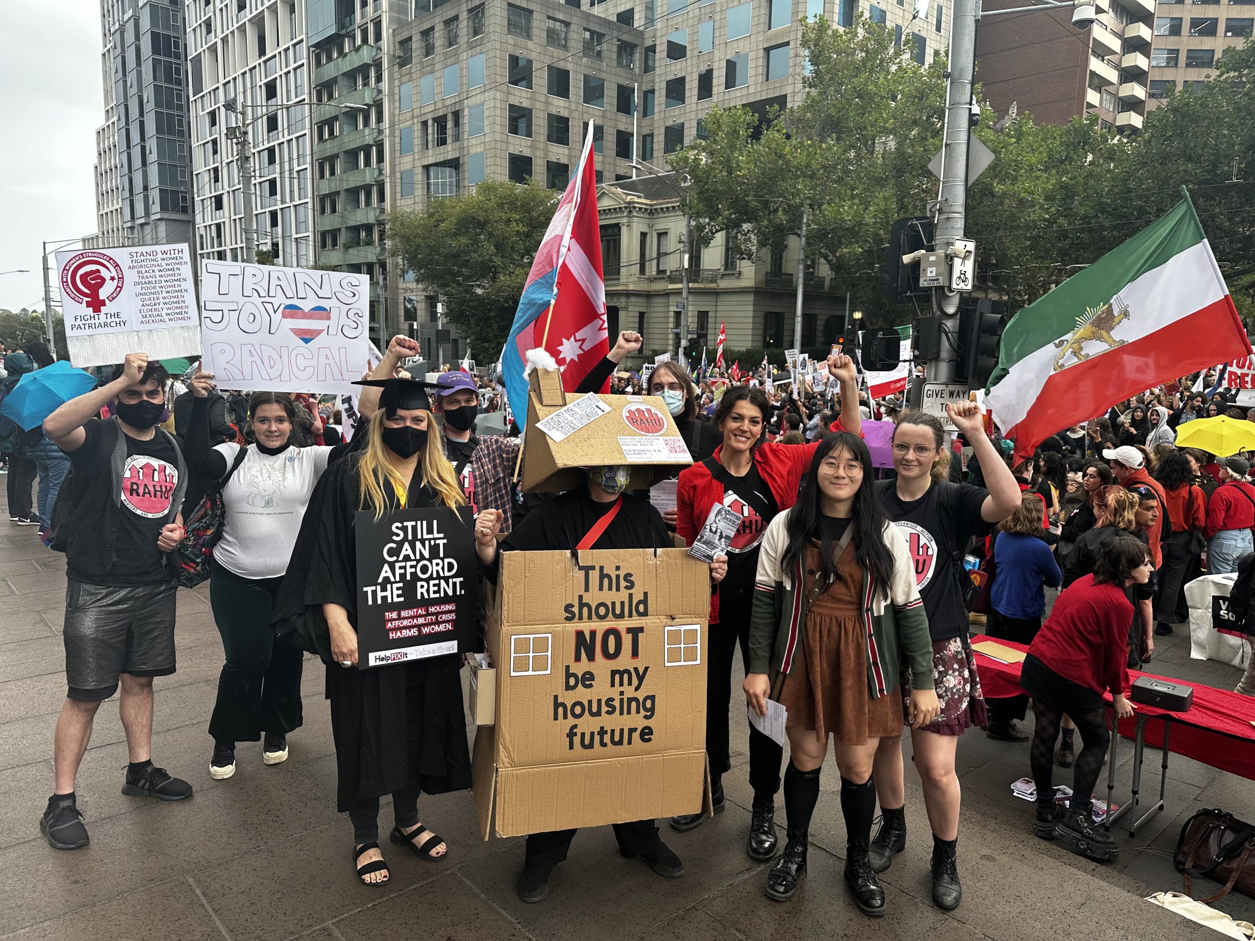 A photo of RAHU at International Women's day march in Narrm.
10 members are standing holding signs with fists raised.